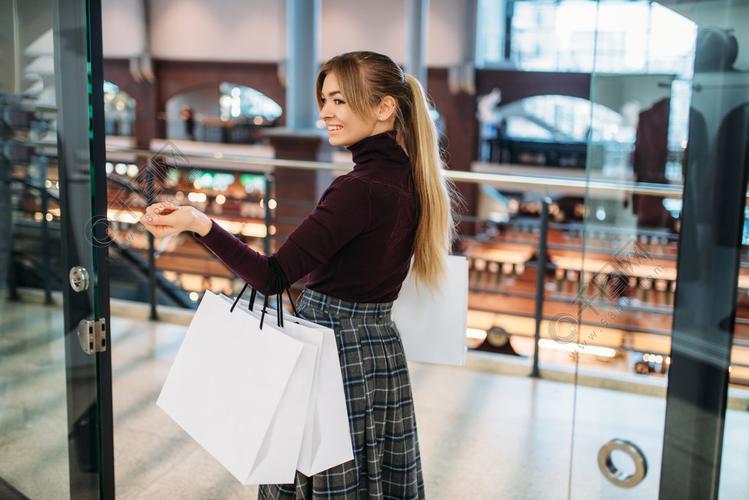 有购物袋的少妇在购物中心服装店的购物狂消费主义生活方式时尚在商店